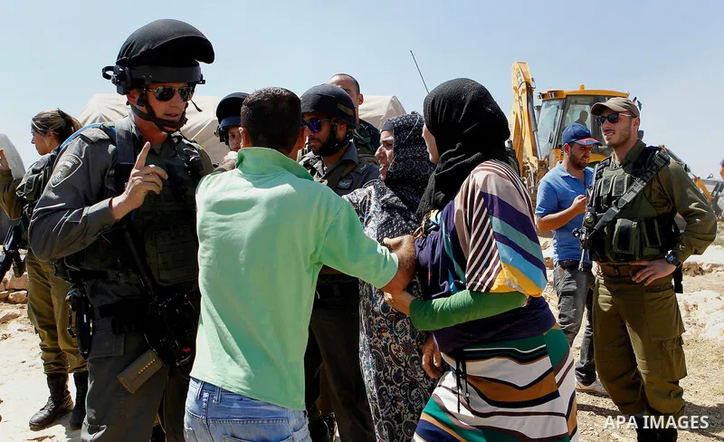 Palestinians scuffle with an Israeli border policeman as Israeli troops demolish sheds belonging to Palestinians near the West Bank village of Yatta, south of Hebron June 19, 2016. Photo by Wisam Hashlamoun