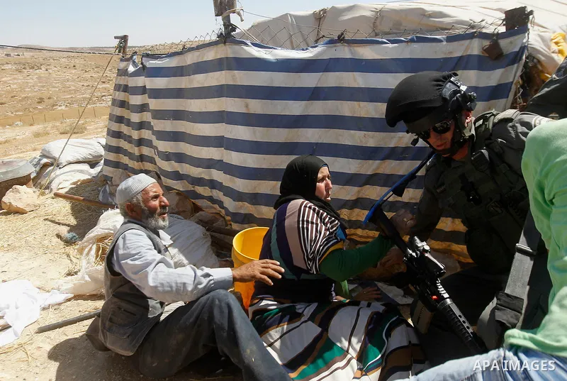 Palestinians scuffle with an Israeli border policeman as Israeli troops demolish sheds belonging to Palestinians near the West Bank village of Yatta, south of Hebron June 19, 2016. Photo by Wisam Hashlamoun