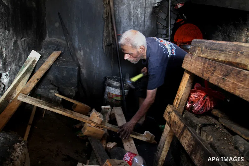 A Palestinian man cooks foods in a traditional mud oven during the holy fasting month of Ramadan, in Rafah in the southern Gaza Strip on June 19, 2016. Ramadan is sacred to Muslims because it is during that month that tr...