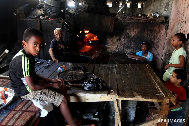 A Palestinian man cooks foods in a traditional mud oven during the holy fasting month of Ramadan, in Rafah in the southern Gaza Strip on June 19, 2016. Ramadan is sacred to Muslims because it is during that month that tr...