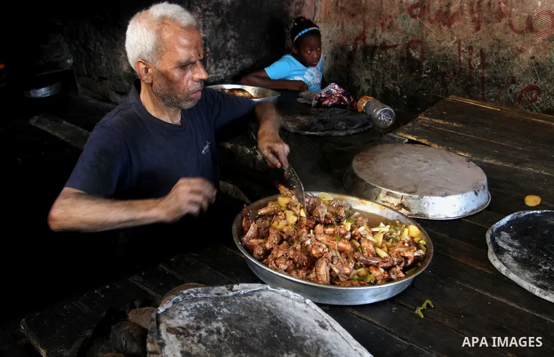A Palestinian man cooks foods in a traditional mud oven during the holy fasting month of Ramadan, in Rafah in the southern Gaza Strip on June 19, 2016. Ramadan is sacred to Muslims because it is during that month that tr...