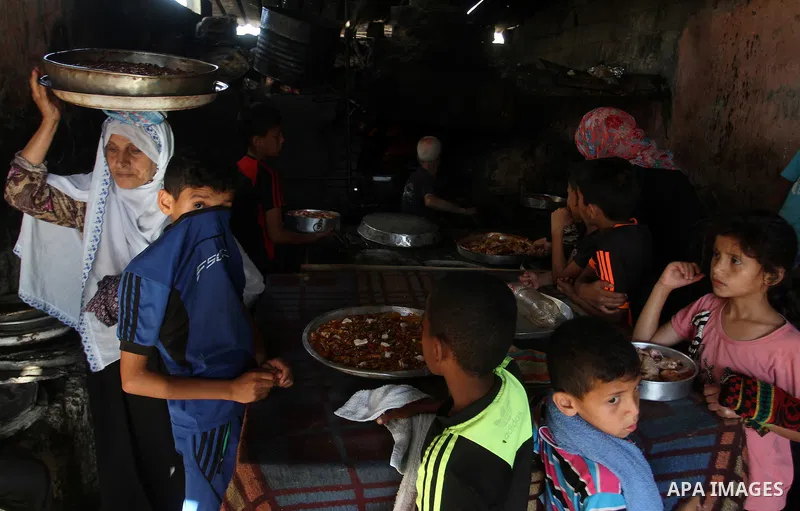 A Palestinian man cooks foods in a traditional mud oven during the holy fasting month of Ramadan, in Rafah in the southern Gaza Strip on June 19, 2016. Ramadan is sacred to Muslims because it is during that month that tr...