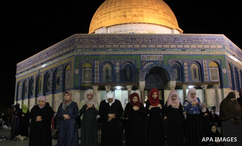 Palestinian Muslim worshippers perform "Taraweeh", nightly prayer of the month of Ramadan, in front of the Dome of the Rock mosque, in Jerusalem's old city on June 20, 2016. Ramadan is sacred to Muslims because it is dur...