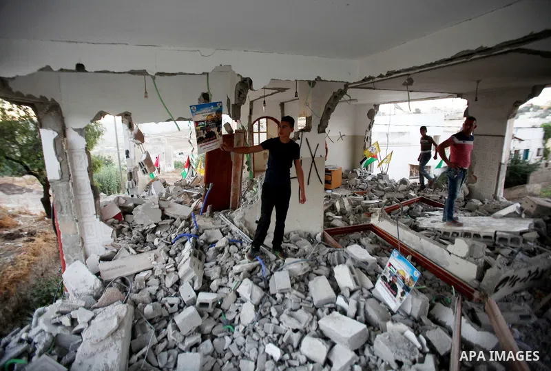 A Palestinian boy inspects the home of the Bashar Masalha that was demolished by the Israeli military in the West bank city of Qalqilya, on June 21, 2016. Bashar Masalha was killed in Jaffa city on 8 March 2016, under th...