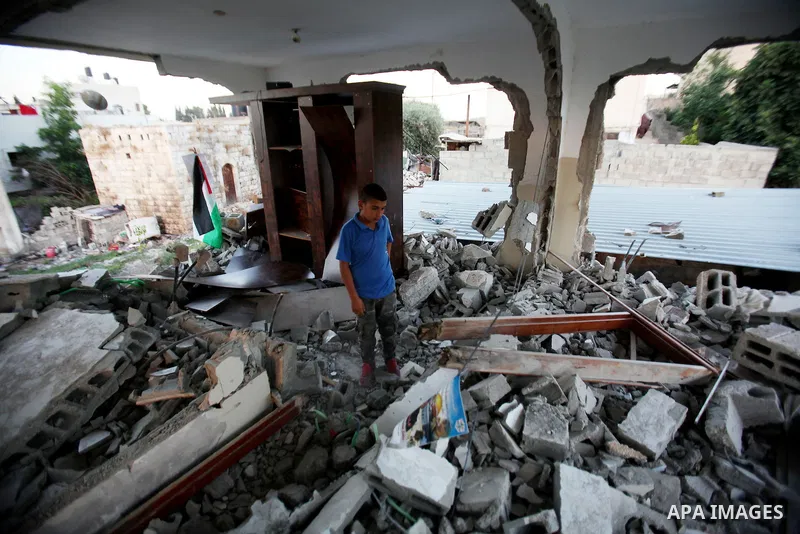 A Palestinian boy inspects the home of the Bashar Masalha that was demolished by the Israeli military in the West bank city of Qalqilya, on June 21, 2016. Bashar Masalha was killed in Jaffa city on 8 March 2016, under th...