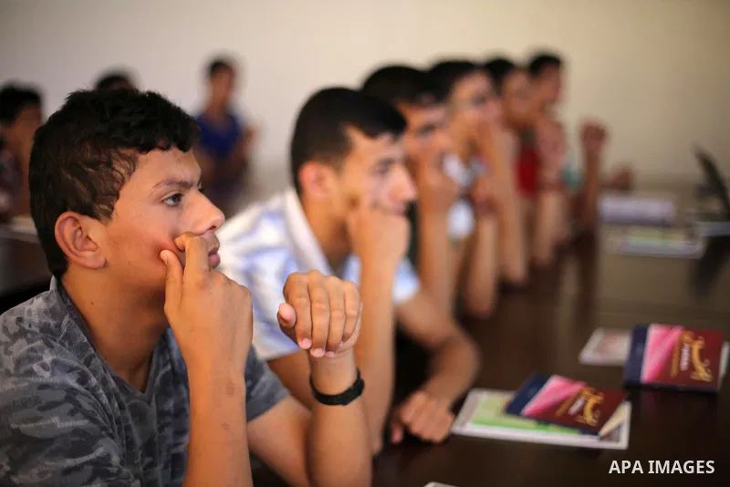 Palestinian deaf students react during A Palestinian imam uses sign-language to teach them the Koran, Islam's holy book at a religion school in Gaza City on June 21 2016, during the Muslim fasting month of Ramadan. Photo...