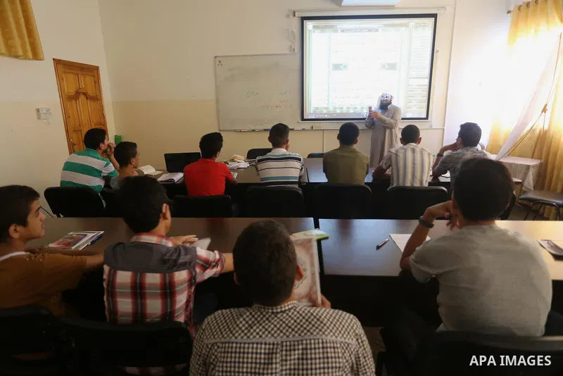 A Palestinian imam uses sign-language to teach the Koran, Islam's holy book, to deaf students at a religion school in Gaza City on June 21 2016, during the Muslim fasting month of Ramadan. Photo by Mohammed Asad