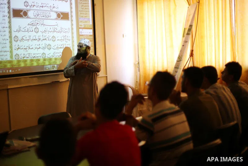 A Palestinian imam uses sign-language to teach the Koran, Islam's holy book, to deaf students at a religion school in Gaza City on June 21 2016, during the Muslim fasting month of Ramadan. Photo by Mohammed Asad