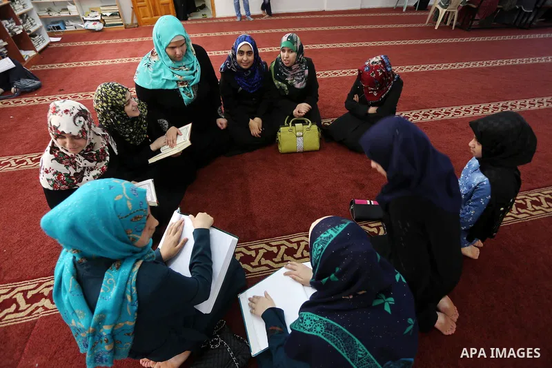 Palestinian blind girls read a copy of the Koran, Islam's holy book, at a religion school in Gaza City on June 21, 2016, during the Muslim fasting month of Ramadan. Photo by Mohammed Asad