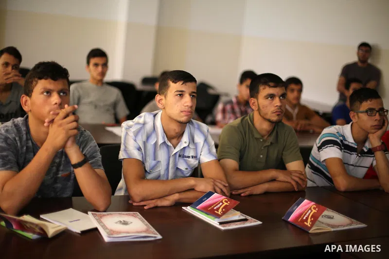Palestinian deaf students react during A Palestinian imam uses sign-language to teach them the Koran, Islam's holy book at a religion school in Gaza City on June 21 2016, during the Muslim fasting month of Ramadan. Photo...