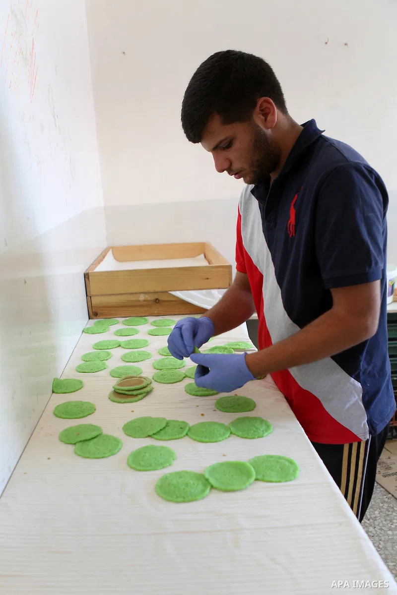 A Palestinian man prepares traditional pancakes known as ''Qatayef" at his shop during the Muslim holy fasting month of Ramadan in the West Bank village of Ein Yabrud near Ramallah on June, 21, 2016. Ramadan is sacred to...