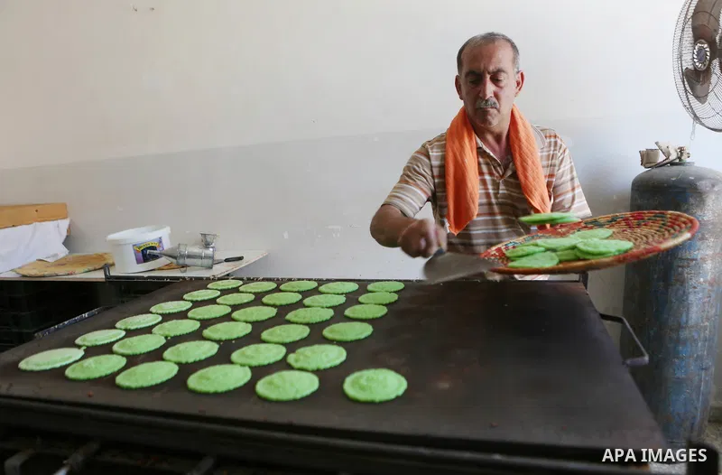 A Palestinian man prepares traditional pancakes known as ''Qatayef" at his shop during the Muslim holy fasting month of Ramadan in the West Bank village of Ein Yabrud near Ramallah on June, 21, 2016. Ramadan is sacred to...
