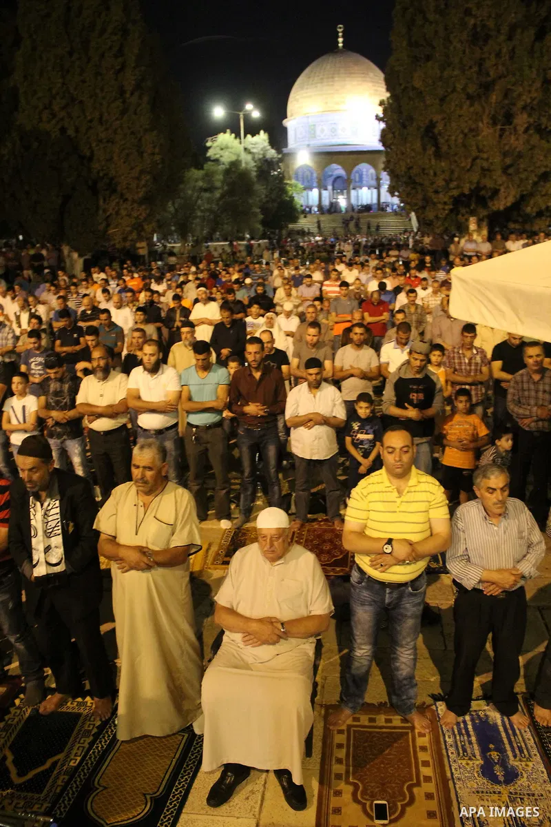 Palestinian Muslim worshippers perform "Taraweeh", nightly prayer of the month of Ramadan, in front of the Dome of the Rock mosque, in Jerusalem's old city on June 21, 2016. Ramadan is sacred to Muslims because it is dur...