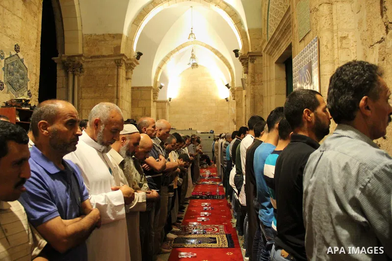 Palestinian Muslim worshippers perform "Taraweeh", nightly prayer of the month of Ramadan, in front of the Dome of the Rock mosque, in Jerusalem's old city on June 21, 2016. Ramadan is sacred to Muslims because it is dur...