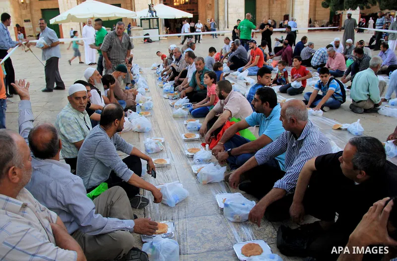 Palestinian muslims prepare to break their fast during the holy fasting month of Ramadan in front of the Dome of the Rock mosque at the al-Aqsa mosque compound, in Jerusalem's old city on June 21, 2016. Ramadan is sacred...