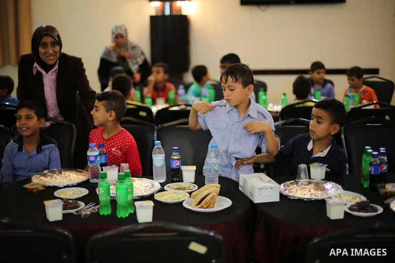 Palestinian orphan children break their fast during the holy fasting month of Ramadan in Gaza city on June 22, 2016. Ramadan is sacred to Muslims because it is during that month that tradition says the Koran was revealed...