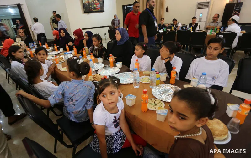 Palestinian orphan children break their fast during the holy fasting month of Ramadan in Gaza city on June 22, 2016. Ramadan is sacred to Muslims because it is during that month that tradition says the Koran was revealed...