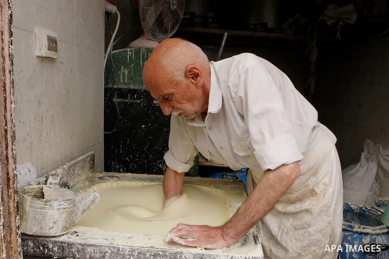 A Palestinian man prepares traditional pancakes known as ''Qatayef'' on the holy month of Ramadan at market in the Old City of the West Bank town of Hebron on June 22, 2016. Ramadan is sacred to Muslims because it is dur...