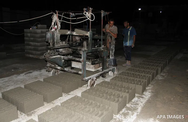Palestinian labourers work at a cement factory at night to avoid the day time heat in Rafah in the southern Gaza Strip on June 22, 2016 during Islam's holy fasting month of Ramadan. Ramadan is sacred to Muslims because i...