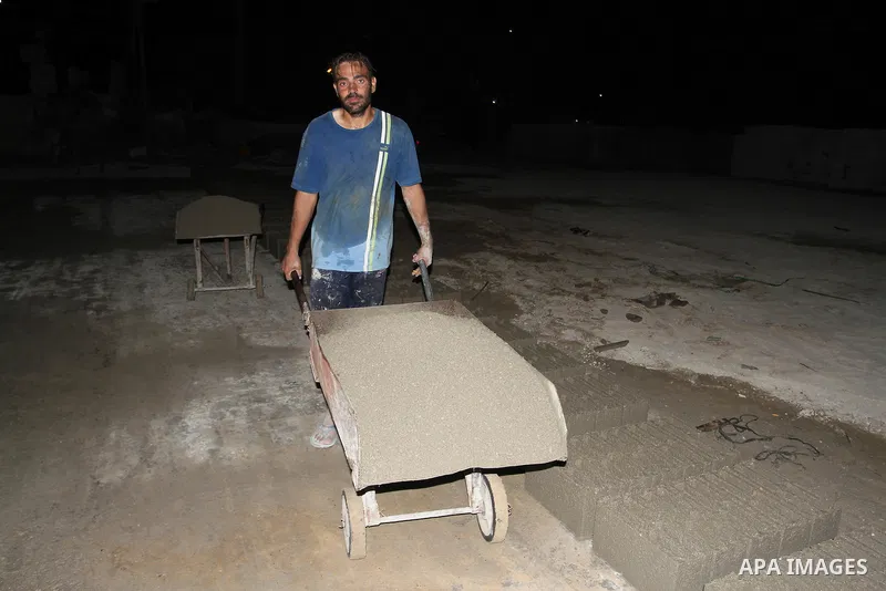 Palestinian labourers work at a cement factory at night to avoid the day time heat in Rafah in the southern Gaza Strip on June 22, 2016 during Islam's holy fasting month of Ramadan. Ramadan is sacred to Muslims because i...