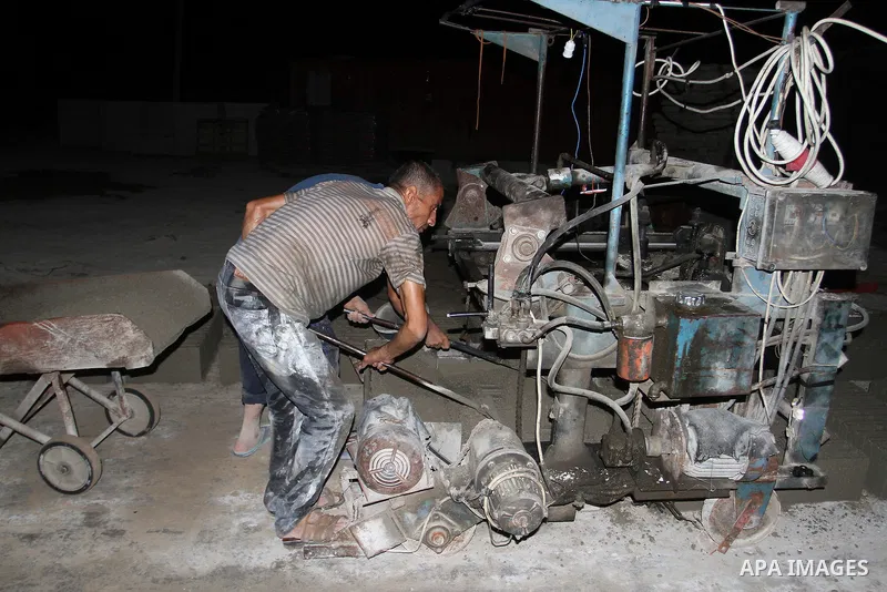 Palestinian labourers work at a cement factory at night to avoid the day time heat in Rafah in the southern Gaza Strip on June 22, 2016 during Islam's holy fasting month of Ramadan. Ramadan is sacred to Muslims because i...
