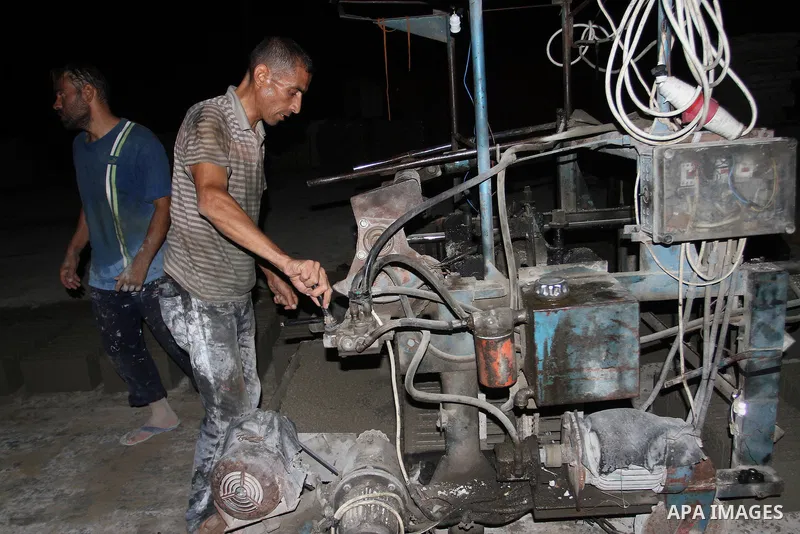 Palestinian labourers work at a cement factory at night to avoid the day time heat in Rafah in the southern Gaza Strip on June 22, 2016 during Islam's holy fasting month of Ramadan. Ramadan is sacred to Muslims because i...