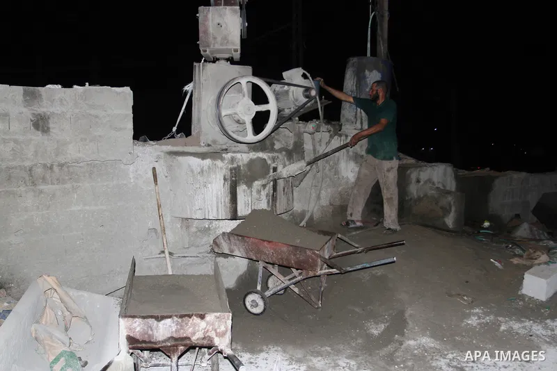 Palestinian labourers work at a cement factory at night to avoid the day time heat in Rafah in the southern Gaza Strip on June 22, 2016 during Islam's holy fasting month of Ramadan. Ramadan is sacred to Muslims because i...