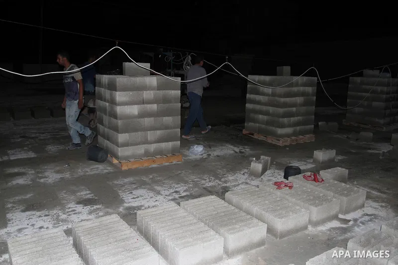 Palestinian labourers work at a cement factory at night to avoid the day time heat in Rafah in the southern Gaza Strip on June 22, 2016 during Islam's holy fasting month of Ramadan. Ramadan is sacred to Muslims because i...