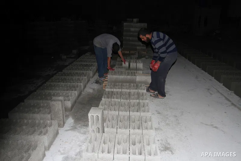 Palestinian labourers work at a cement factory at night to avoid the day time heat in Rafah in the southern Gaza Strip on June 22, 2016 during Islam's holy fasting month of Ramadan. Ramadan is sacred to Muslims because i...