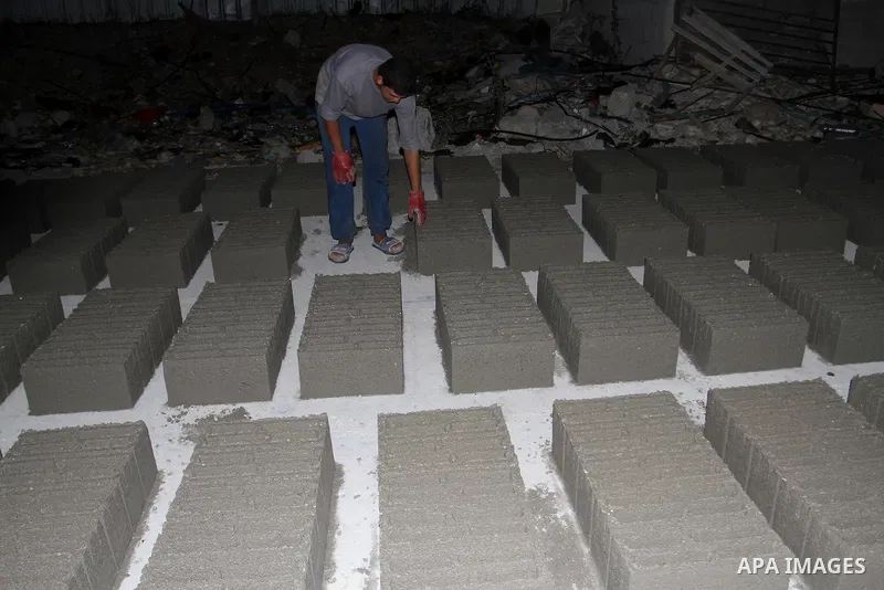 Palestinian labourers work at a cement factory at night to avoid the day time heat in Rafah in the southern Gaza Strip on June 22, 2016 during Islam's holy fasting month of Ramadan. Ramadan is sacred to Muslims because i...