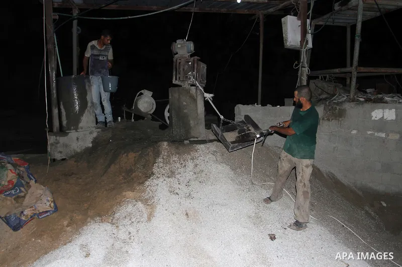 Palestinian labourers work at a cement factory at night to avoid the day time heat in Rafah in the southern Gaza Strip on June 22, 2016 during Islam's holy fasting month of Ramadan. Ramadan is sacred to Muslims because i...