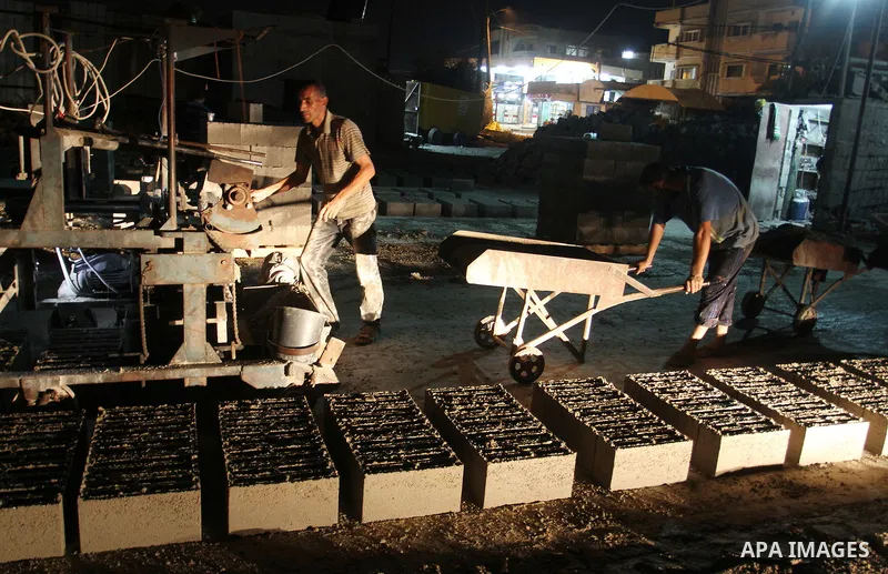Palestinian labourers work at a cement factory at night to avoid the day time heat in Rafah in the southern Gaza Strip on June 22, 2016 during Islam's holy fasting month of Ramadan. Ramadan is sacred to Muslims because i...