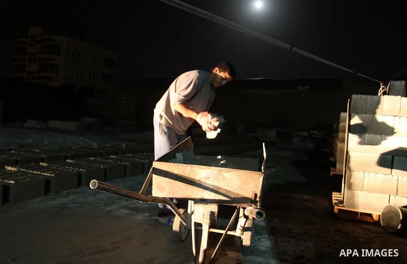 Palestinian labourers work at a cement factory at night to avoid the day time heat in Rafah in the southern Gaza Strip on June 22, 2016 during Islam's holy fasting month of Ramadan. Ramadan is sacred to Muslims because i...