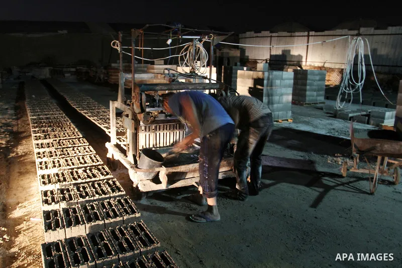 Palestinian labourers work at a cement factory at night to avoid the day time heat in Rafah in the southern Gaza Strip on June 22, 2016 during Islam's holy fasting month of Ramadan. Ramadan is sacred to Muslims because i...