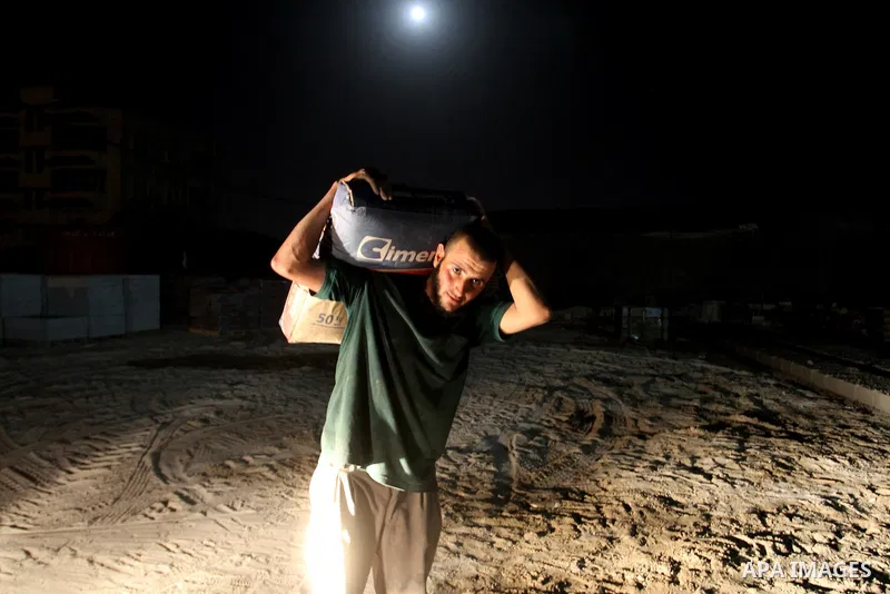 Palestinian labourers work at a cement factory at night to avoid the day time heat in Rafah in the southern Gaza Strip on June 22, 2016 during Islam's holy fasting month of Ramadan. Ramadan is sacred to Muslims because i...