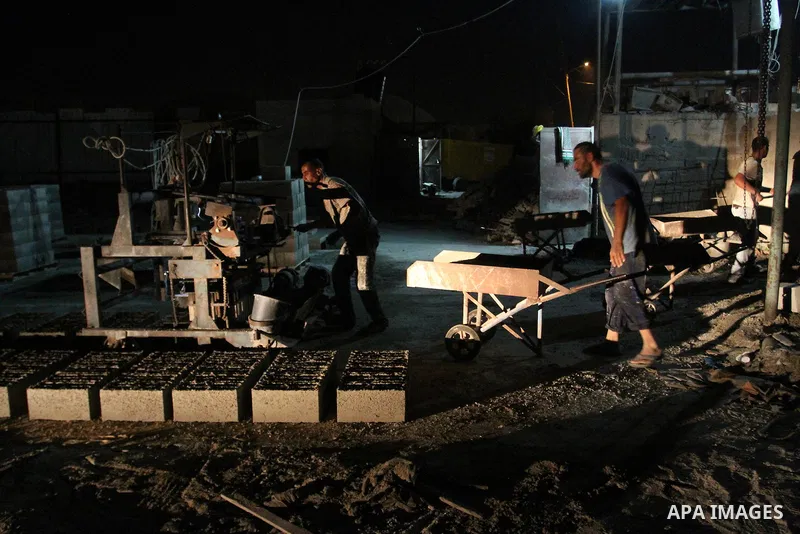 Palestinian labourers work at a cement factory at night to avoid the day time heat in Rafah in the southern Gaza Strip on June 22, 2016 during Islam's holy fasting month of Ramadan. Ramadan is sacred to Muslims because i...