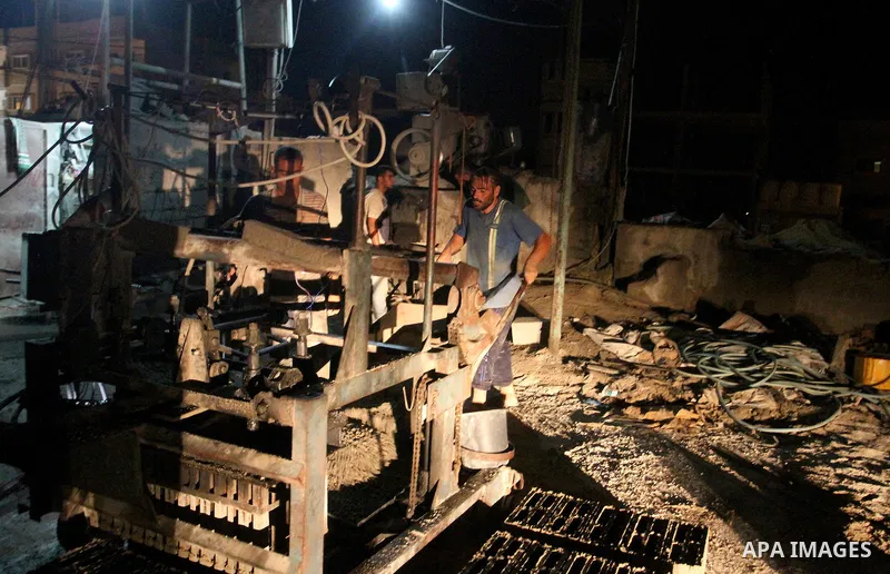 Palestinian labourers work at a cement factory at night to avoid the day time heat in Rafah in the southern Gaza Strip on June 22, 2016 during Islam's holy fasting month of Ramadan. Ramadan is sacred to Muslims because i...