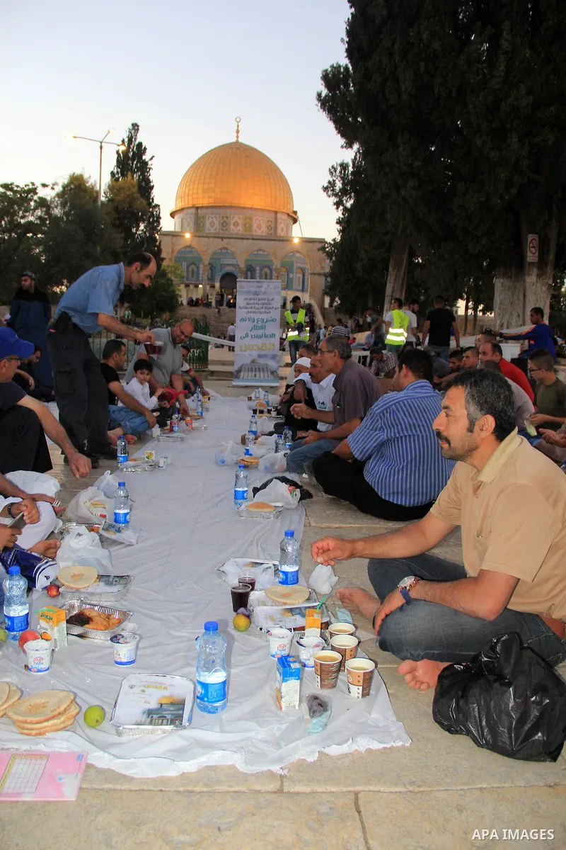 Palestinian muslims prepare to break their fast during the holy fasting month of Ramadan in front of the Dome of the Rock mosque at the al-Aqsa mosque compound, in Jerusalem's old city on June 22, 2016. Ramadan is sacred...