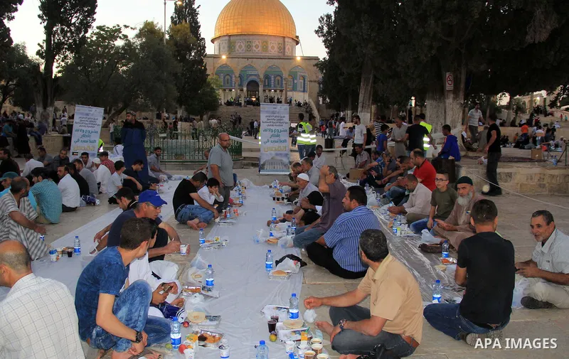 Palestinian muslims prepare to break their fast during the holy fasting month of Ramadan in front of the Dome of the Rock mosque at the al-Aqsa mosque compound, in Jerusalem's old city on June 22, 2016. Ramadan is sacred...
