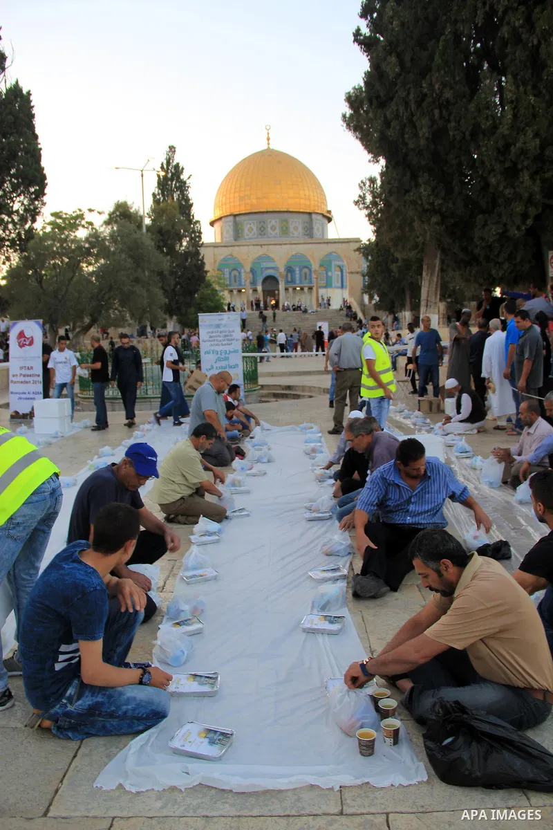 Palestinian muslims prepare to break their fast during the holy fasting month of Ramadan in front of the Dome of the Rock mosque at the al-Aqsa mosque compound, in Jerusalem's old city on June 22, 2016. Ramadan is sacred...