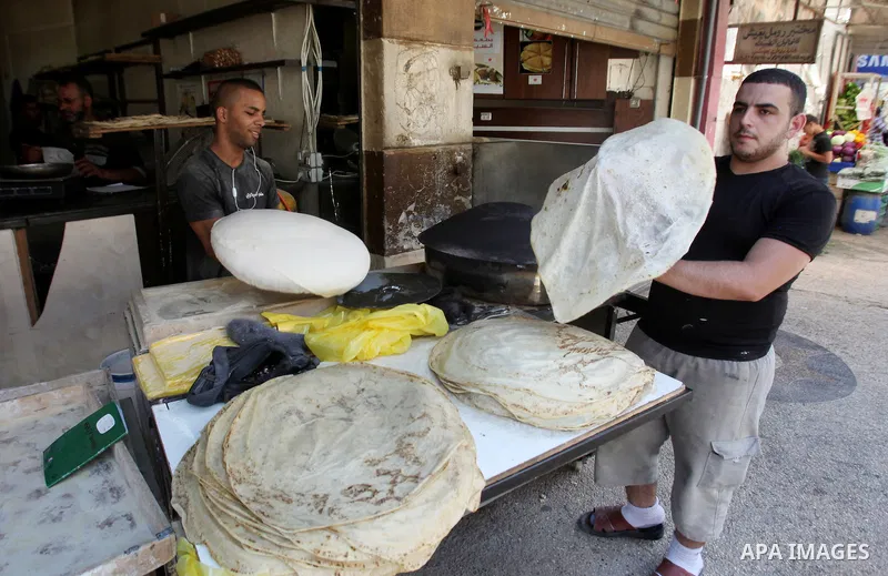A Palestinian man bakes loaves of bread in a street market on the holy month of Ramadan, in the West Bank city of Nablus on June 23, 2016. Ramadan is sacred to Muslims because it is during that month that tradition says...