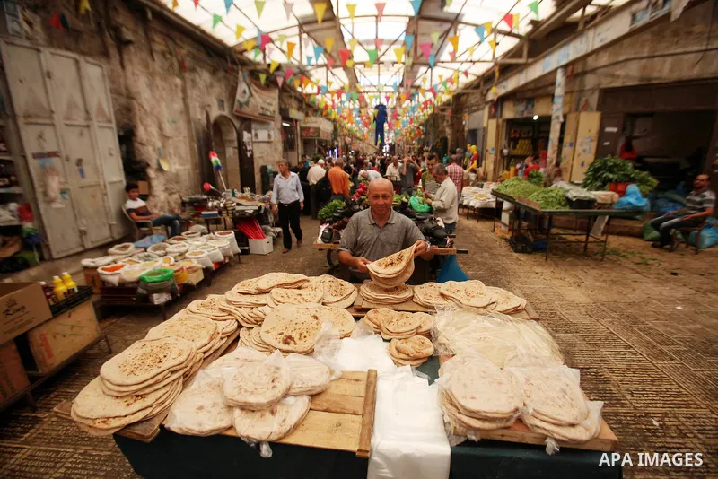 A Palestinian vendor sells breads in a street market on the holy month of Ramadan, in the West Bank city of Nablus on June 23, 2016. Ramadan is sacred to Muslims because it is during that month that tradition says the Ko...