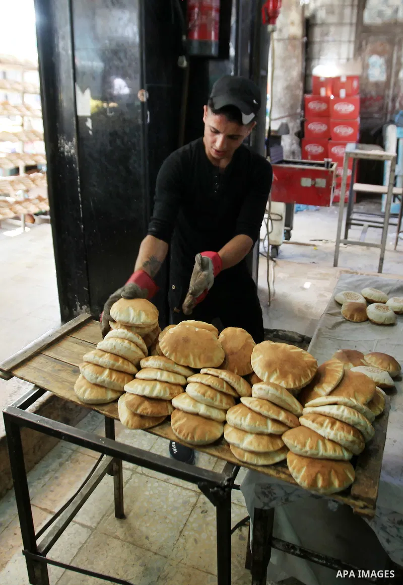 A Palestinian vendor sells breads in a street market on the holy month of Ramadan, in the West Bank city of Nablus on June 23, 2016. Ramadan is sacred to Muslims because it is during that month that tradition says the Ko...