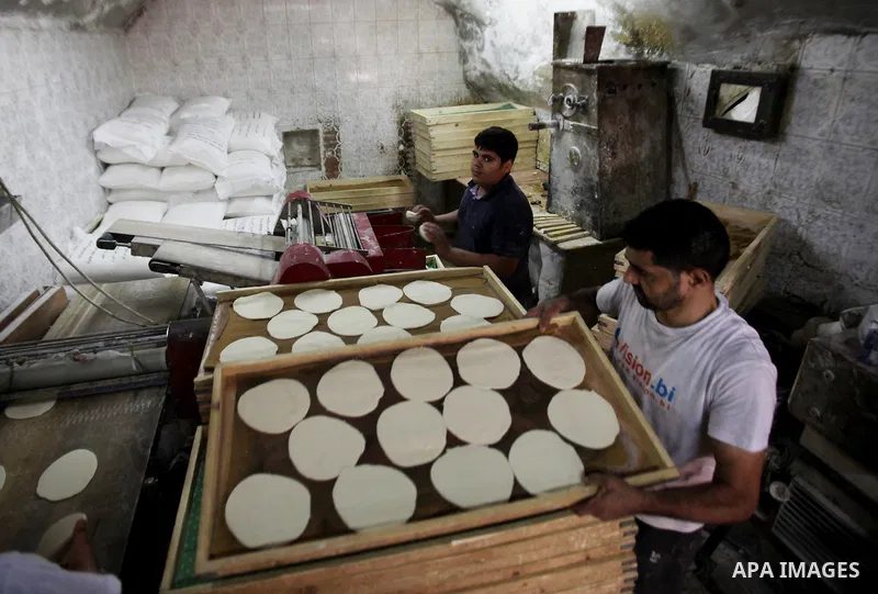 A Palestinian man bakes loaves of bread in a street market on the holy month of Ramadan, in the West Bank city of Nablus on June 23, 2016. Ramadan is sacred to Muslims because it is during that month that tradition says...