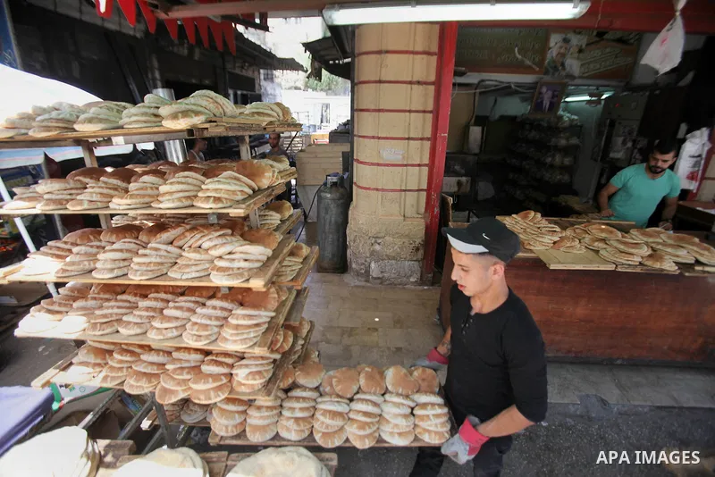 A Palestinian vendor sells breads in a street market on the holy month of Ramadan, in the West Bank city of Nablus on June 23, 2016. Ramadan is sacred to Muslims because it is during that month that tradition says the Ko...