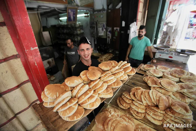 A Palestinian vendor sells breads in a street market on the holy month of Ramadan, in the West Bank city of Nablus on June 23, 2016. Ramadan is sacred to Muslims because it is during that month that tradition says the Ko...
