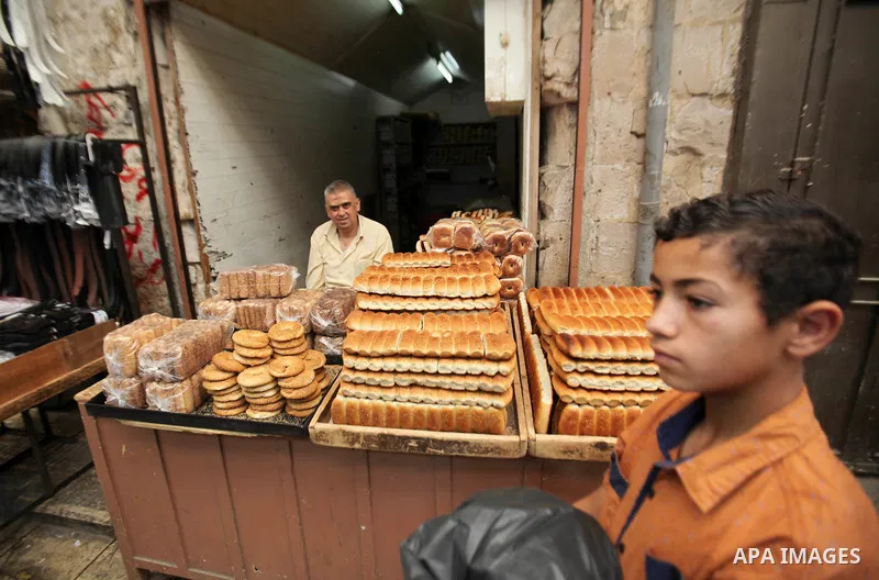 A Palestinian vendor sells breads in a street market on the holy month of Ramadan, in the West Bank city of Nablus on June 23, 2016. Ramadan is sacred to Muslims because it is during that month that tradition says the Ko...