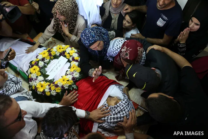 The mother of Palestinian boy Mahmoud Badran, 15, who was killed by Israeli troops on Tuesday, kisses his body during his funeral in the village of Beit Ore-Tahta near the West Bank city of Ramallah June 23, 2016. Photo...