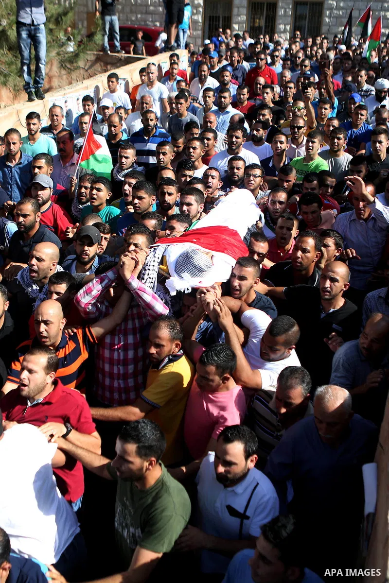 Mourners carry the body of Palestinian boy Mahmoud Badran, 15, who was killed by Israeli troops on Tuesday, during his funeral in the village of Beit Ore-Tahta near the West Bank city of Ramallah June 23, 2016. Photo by...