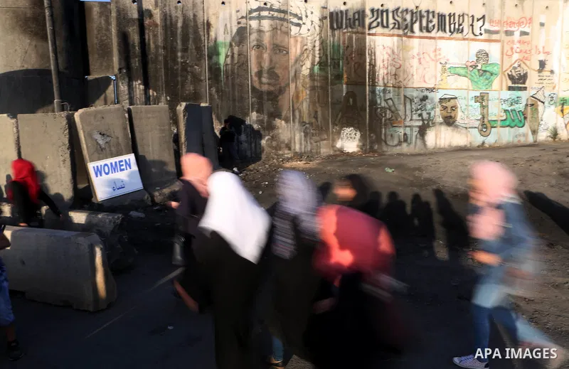 Palestinians walk past Qalandia checkpoint between the West Bank city of Ramallah and Jerusalem on June 24, 2016, as they head to Jerusalem's Al-Aqsa mosque for the third Friday prayer of the holy Muslim fasting month of...